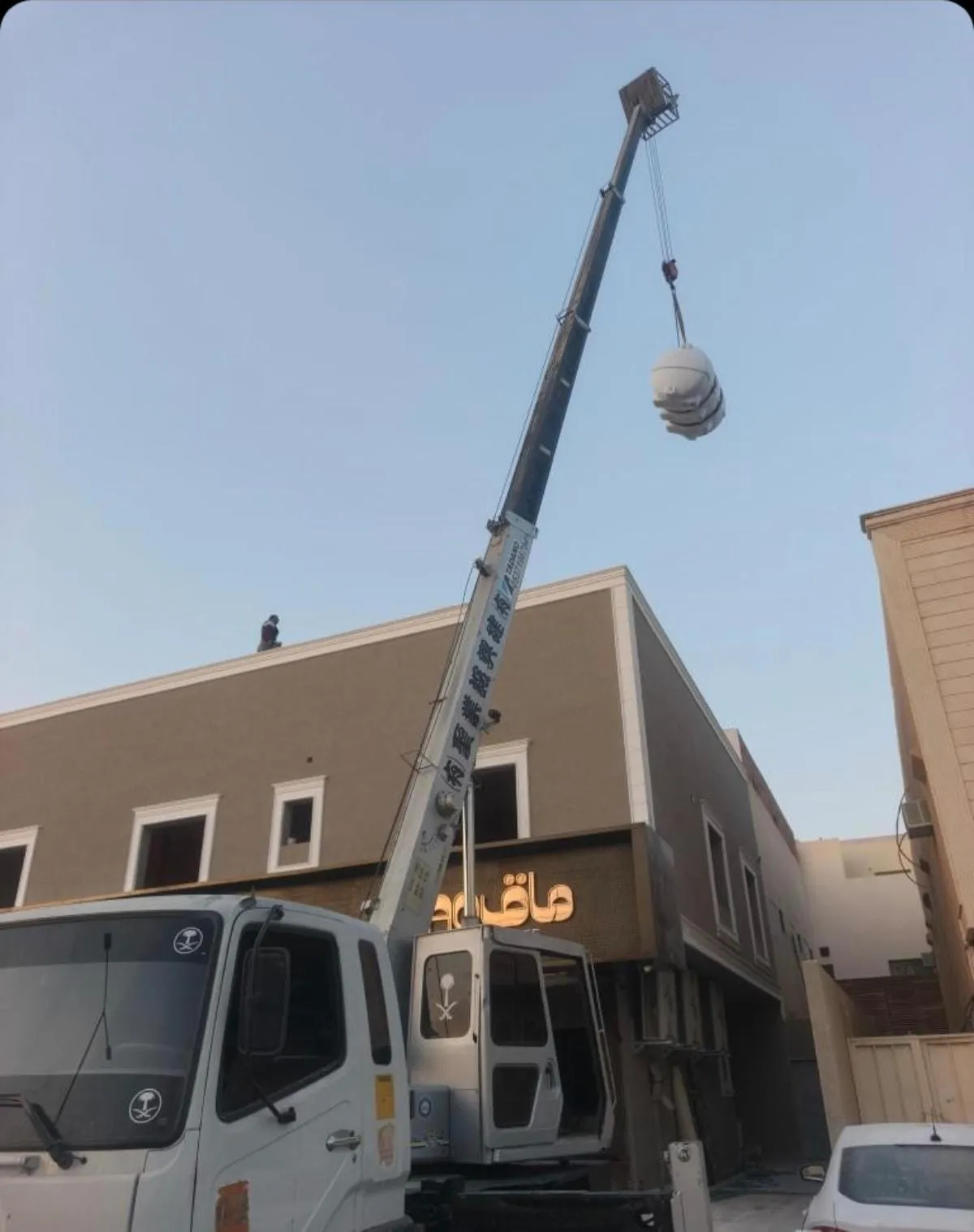 كرين بريدة يرفع حمولة في موقع بناء